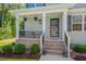 Inviting front porch with brick steps, hanging plants, and cozy seating area at 40 Otter Ct, Youngsville, NC 27596