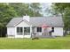 Exterior of a home with a well-maintained backyard, featuring a deck, lush green grass, and treed area at 404 Denton St, Durham, NC 27713