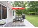 Backyard featuring a deck with a red umbrella, table and benches, backing onto a treed area at 404 Denton St, Durham, NC 27713