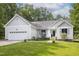 Charming home with a manicured lawn, attached garage, and inviting curb appeal under a partly cloudy sky at 404 Denton St, Durham, NC 27713