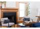 Close up of the warm living room fireplace with hardwood floors, natural light, and comfortable seating at 404 Denton St, Durham, NC 27713