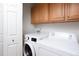 Bright laundry room features a stacked washer and dryer with wooden cabinets above for storage at 404 Denton St, Durham, NC 27713