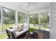 Bright sunroom featuring a futon with accent pillows, surrounded by windows offering serene views of the backyard at 404 Denton St, Durham, NC 27713
