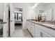 Well-lit bathroom featuring double sinks, stylish countertops, and a doorway that offers a glimpse into the main bedroom at 404 Porterfield Dr, Youngsville, NC 27596