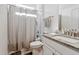 Well-lit bathroom featuring a granite vanity and shower with white tiled walls at 404 Porterfield Dr, Youngsville, NC 27596