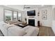 Cozy living room with a fireplace, large windows, a ceiling fan, and comfortable seating at 404 Porterfield Dr, Youngsville, NC 27596