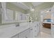 Bathroom featuring a large mirror over double sinks and white cabinets with views to the bedroom at 404 Wanderview Ln, Holly Springs, NC 27540