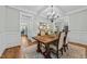 Elegant dining room featuring wainscoting, coffered ceilings, a chandelier, and a view into other living spaces at 404 Wanderview Ln, Holly Springs, NC 27540