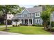 Beautiful two-story home with a blue exterior, lush lawn, and a two-car garage, complemented by mature trees and landscaping at 404 Wanderview Ln, Holly Springs, NC 27540
