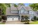 Charming two-story home with a covered front porch, blue siding, white trim, and a two-car garage with ample driveway space at 404 Wanderview Ln, Holly Springs, NC 27540