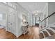 Bright foyer with hardwood floors, staircase, transom windows, and a view through the glass door to the outside at 404 Wanderview Ln, Holly Springs, NC 27540
