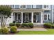 Inviting front porch with stone accents, comfy seating, decorative plants, and a stylish front door with house number displayed at 404 Wanderview Ln, Holly Springs, NC 27540