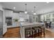 Modern kitchen featuring a large island with seating, white cabinets, stainless steel appliances, and hardwood floors at 404 Wanderview Ln, Holly Springs, NC 27540