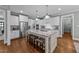 Well-lit kitchen with a center island, seating, and stainless steel refrigerator at 404 Wanderview Ln, Holly Springs, NC 27540