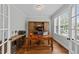 Bright office with a large wooden desk, storage cabinets, and a window overlooking the front yard at 404 Wanderview Ln, Holly Springs, NC 27540