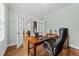 Stylish home office with hardwood floors, a large wooden desk, a comfortable chair, and natural light streaming in at 404 Wanderview Ln, Holly Springs, NC 27540