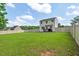 Expansive backyard with lush green grass, privacy fence, and the home's back elevation at 411 Buxton St, Durham, NC 27713