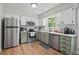 Updated kitchen featuring stainless steel appliances, white cabinets, and a large window providing natural light at 411 Buxton St, Durham, NC 27713