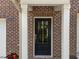 Close-up of the red brick front entrance, showcasing a dark door and white trim at 4124 Sykes St, Cary, NC 27519