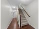 Hallway with hardwood floors, staircase, and neutral walls leading to various rooms at 4124 Sykes St, Cary, NC 27519