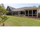 Side view of backyard showing covered patio with outdoor furniture and manicured lawn enclosed by a black fence at 428 Crayton Oak Dr, Cary, NC 27519