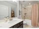 Well-lit bathroom features a vanity with white countertop and shower over bath with orange shower curtain at 428 Crayton Oak Dr, Cary, NC 27519