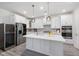 Modern kitchen with stainless steel appliances, white cabinetry, and a central island with marble countertop at 428 Crayton Oak Dr, Cary, NC 27519