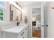Well-lit bathroom featuring a white vanity with black hardware and a view into the bedroom at 433 Rosehaven Dr, Raleigh, NC 27609
