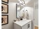 Charming powder room featuring a stylish vanity, black hardware and decorative artwork at 433 Rosehaven Dr, Raleigh, NC 27609