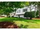 Charming two-story home with white painted brick, gray shutters, mature trees, and a beautifully landscaped front yard at 433 Rosehaven Dr, Raleigh, NC 27609