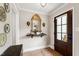 Inviting foyer features a decorative mirror over a console table and a beautiful wood door at 433 Rosehaven Dr, Raleigh, NC 27609