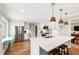 Modern kitchen with white cabinets, stainless steel appliances, and light hardwood flooring at 433 Rosehaven Dr, Raleigh, NC 27609