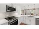 Close-up of modern kitchen with stainless steel appliances and white cabinetry at 433 Rosehaven Dr, Raleigh, NC 27609