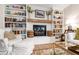Living room with a white brick fireplace, a wooden mantel, built-in bookshelves and a plush white sofa at 433 Rosehaven Dr, Raleigh, NC 27609