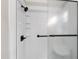 Shower with dark bronze fixtures, built-in shelves, and textured glass sliding door at 433 Rosehaven Dr, Raleigh, NC 27609