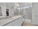 Bright bathroom featuring double sinks, quartz countertop, and glass-enclosed shower with bench at 450 S Parliament Way, Clayton, NC 27520