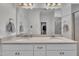 Bathroom featuring double sinks, white cabinets, and a large mirror at 450 S Parliament Way, Clayton, NC 27520