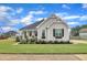 Charming home with manicured lawn, stone accents, and inviting entrance, set against a backdrop of blue skies at 450 S Parliament Way, Clayton, NC 27520