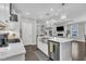 Modern kitchen features white cabinets, stainless steel appliances, kitchen island and seamless flow to the living area at 450 S Parliament Way, Clayton, NC 27520