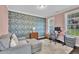 Cozy home office featuring stylish wallpaper, natural light, a comfortable seating area, and an organized workspace at 450 S Parliament Way, Clayton, NC 27520