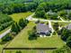 Aerial view showcases a modern home with an outdoor patio, lush green lawn, and a privacy fence, set against a backdrop of mature trees at 4621 Basilica Dr, Holly Springs, NC 27540