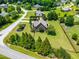 Aerial view showcases a home surrounded by manicured lawns, mature trees, and landscaped flowerbeds, highlighting the property's curb appeal at 4621 Basilica Dr, Holly Springs, NC 27540