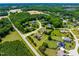 Expansive aerial view of a brick home featuring a lush, fenced backyard surrounded by mature trees and landscaped grounds at 4621 Basilica Dr, Holly Springs, NC 27540