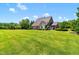 Expansive backyard with lush green grass, mature trees, and beautiful landscaping, creating a serene outdoor retreat at 4621 Basilica Dr, Holly Springs, NC 27540