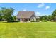 Backyard showcasing a well-maintained lawn, mature trees, and patio seating for comfortable outdoor living and entertainment at 4621 Basilica Dr, Holly Springs, NC 27540