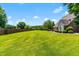 Lush backyard features an expansive lawn, mature trees, and elegant landscaping that create an inviting outdoor space at 4621 Basilica Dr, Holly Springs, NC 27540