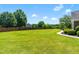 Well-manicured backyard featuring a large green lawn, mature trees, and elegant landscaping for relaxation and recreation at 4621 Basilica Dr, Holly Springs, NC 27540