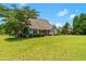 Spacious backyard featuring lush lawn, mature trees, and covered patio, perfect for outdoor gatherings and relaxation at 4621 Basilica Dr, Holly Springs, NC 27540