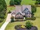 Elegant brick home with a manicured front lawn and a circular driveway, showcasing its grand entrance at 4621 Basilica Dr, Holly Springs, NC 27540