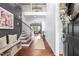 Inviting foyer with hardwood floors, paneled walls, staircase, bench, and natural light at 4621 Basilica Dr, Holly Springs, NC 27540